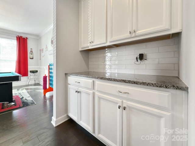 kitchen featuring dark stone counters, dark hardwood / wood-style floors, decorative backsplash, and white cabinets