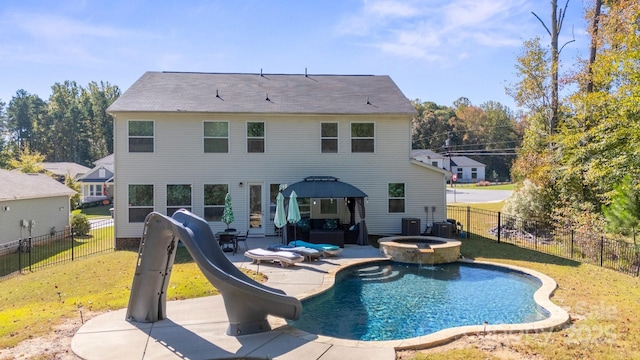 back of property with a gazebo, a lawn, a pool with hot tub, cooling unit, and a patio