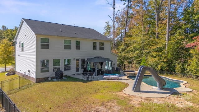 rear view of house featuring a fenced in pool, a patio, cooling unit, and a lawn