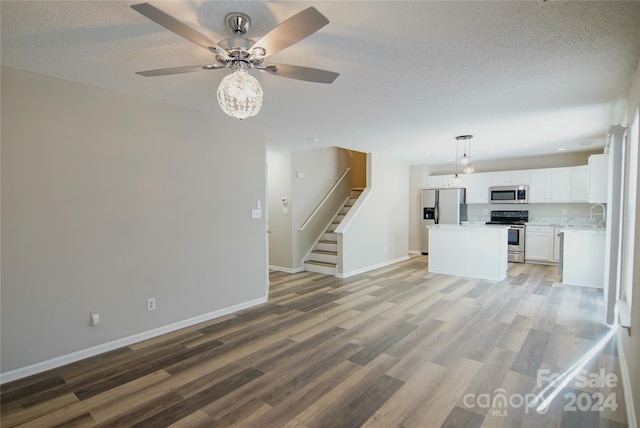 unfurnished living room with a textured ceiling, ceiling fan, and light hardwood / wood-style flooring