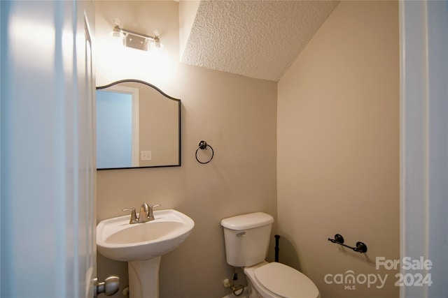 bathroom featuring sink, a textured ceiling, and toilet