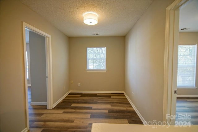 empty room featuring dark wood-type flooring and a textured ceiling