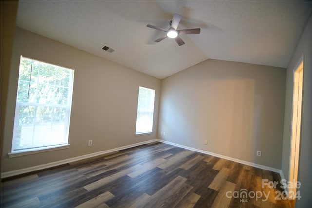 spare room with dark wood-type flooring, lofted ceiling, a textured ceiling, and ceiling fan