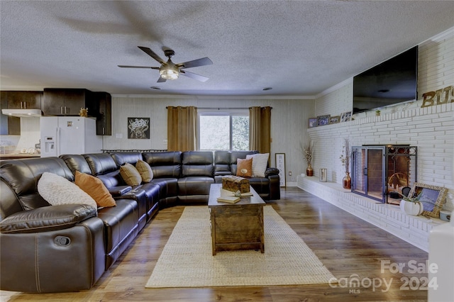 living room with light hardwood / wood-style floors, a textured ceiling, and a fireplace