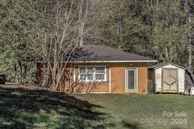 view of front facade featuring a front yard and a storage unit