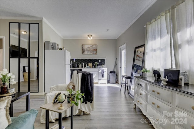 interior space with ornamental molding, a textured ceiling, and light wood-type flooring