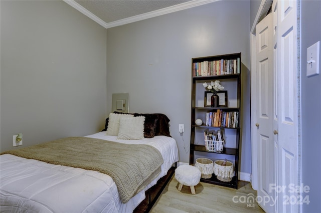 bedroom with crown molding and light wood-type flooring