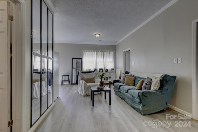 living room featuring a textured ceiling, ornamental molding, and light hardwood / wood-style flooring