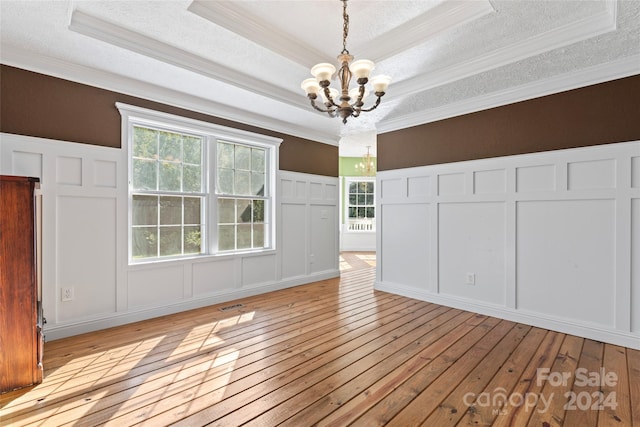 interior space with ornamental molding, light wood-type flooring, an inviting chandelier, and a textured ceiling