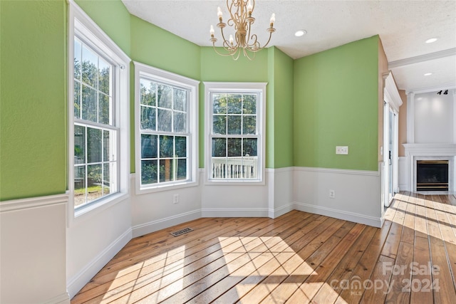 2720 Lentz Rd, China Grove, NC 28023 - unfurnished dining area featuring an inviting chandelier, visible vents, baseboards, hardwood / wood-style flooring, and a large fireplace