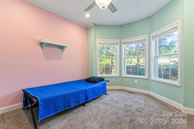 carpeted bedroom with crown molding and ceiling fan