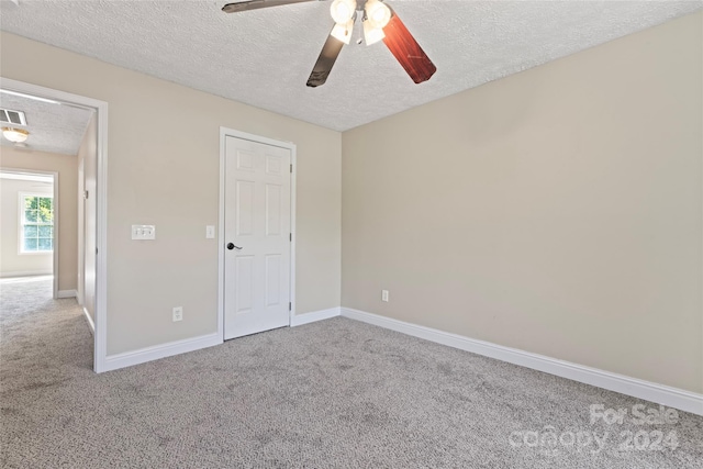 unfurnished bedroom with carpet flooring, a textured ceiling, and ceiling fan