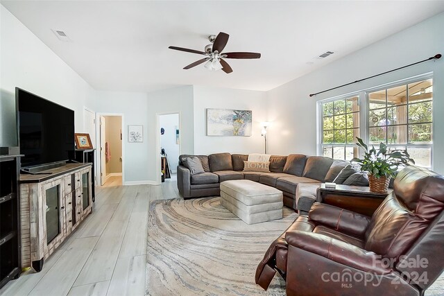 living room featuring ceiling fan and light hardwood / wood-style flooring