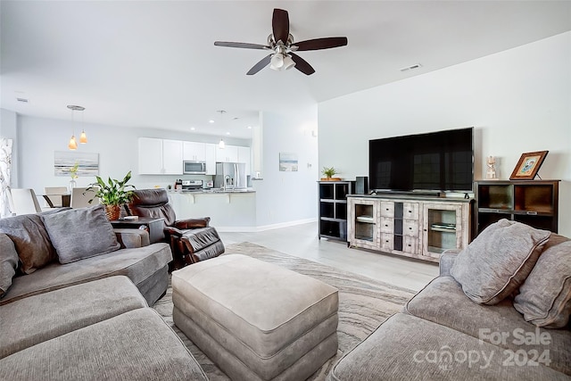 living room with light hardwood / wood-style floors and ceiling fan