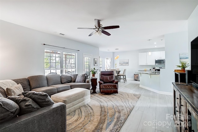 living room featuring light hardwood / wood-style floors and ceiling fan