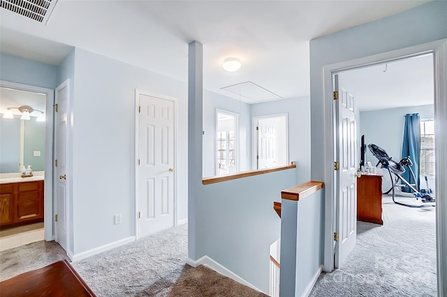 hallway featuring light colored carpet