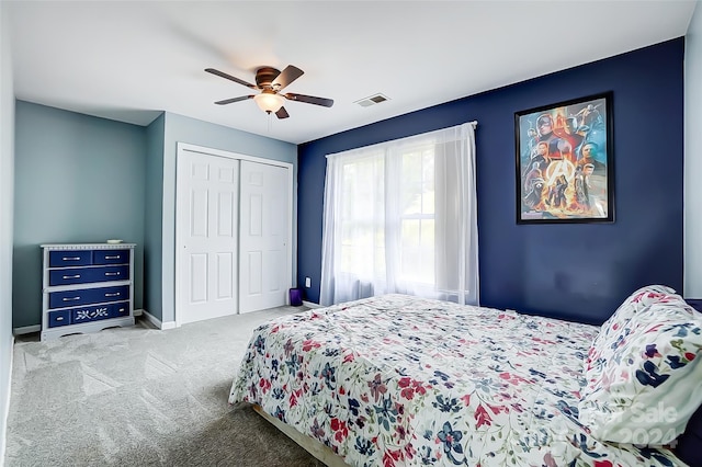 carpeted bedroom featuring ceiling fan and a closet