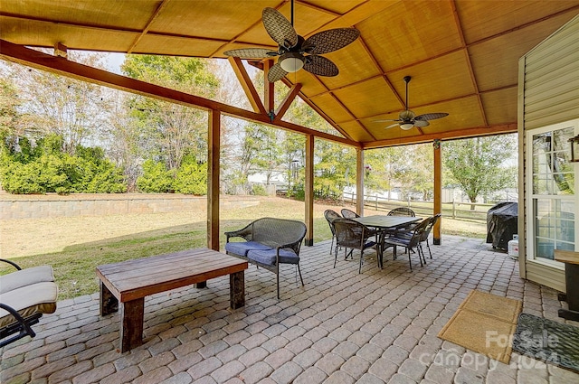 unfurnished sunroom with lofted ceiling, ceiling fan, and wooden ceiling