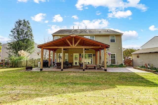 rear view of house with a patio, a lawn, and ceiling fan