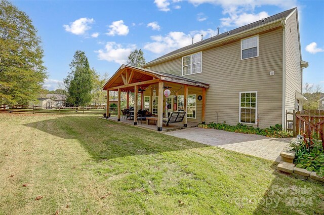 back of property featuring a lawn and a patio