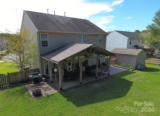 rear view of house featuring an outdoor fire pit, a lawn, and a patio area