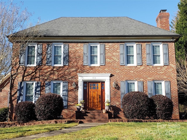 colonial-style house with a front yard