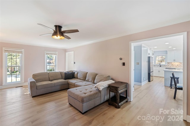 living room with ceiling fan, sink, light hardwood / wood-style flooring, and ornamental molding