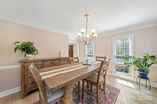 dining room with crown molding, an inviting chandelier, and light hardwood / wood-style flooring