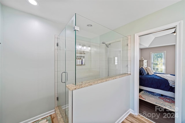 bathroom featuring hardwood / wood-style flooring and walk in shower