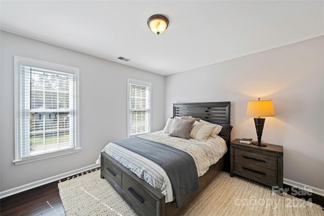 bedroom with hardwood / wood-style floors and multiple windows