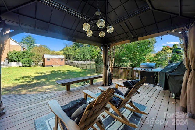 wooden deck with a gazebo, a yard, and a storage unit