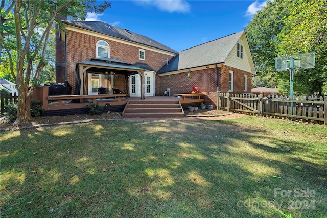 rear view of house with a deck and a lawn