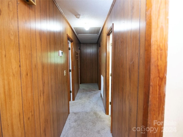 corridor featuring light carpet and wooden walls