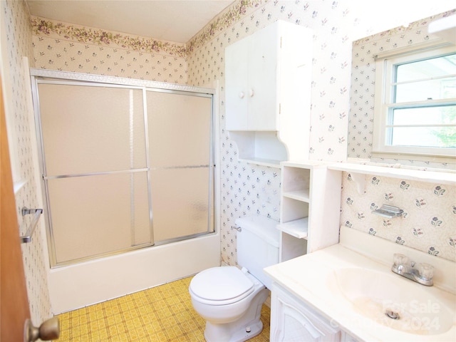 full bathroom featuring vanity, enclosed tub / shower combo, and toilet