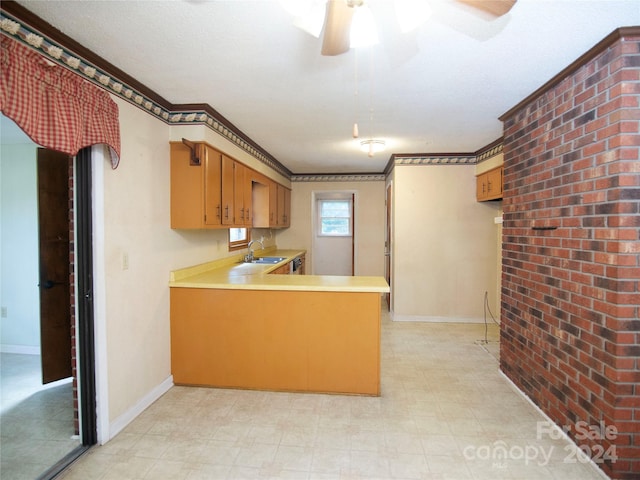 kitchen featuring ceiling fan, crown molding, sink, kitchen peninsula, and a textured ceiling