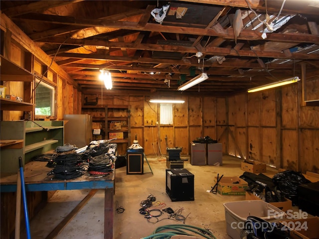 basement with wooden walls and a workshop area