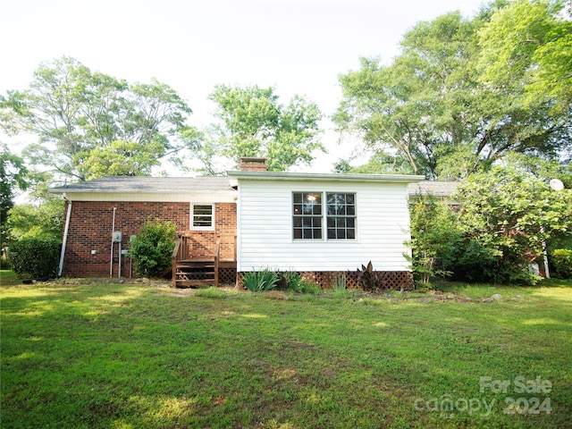 rear view of house featuring a yard