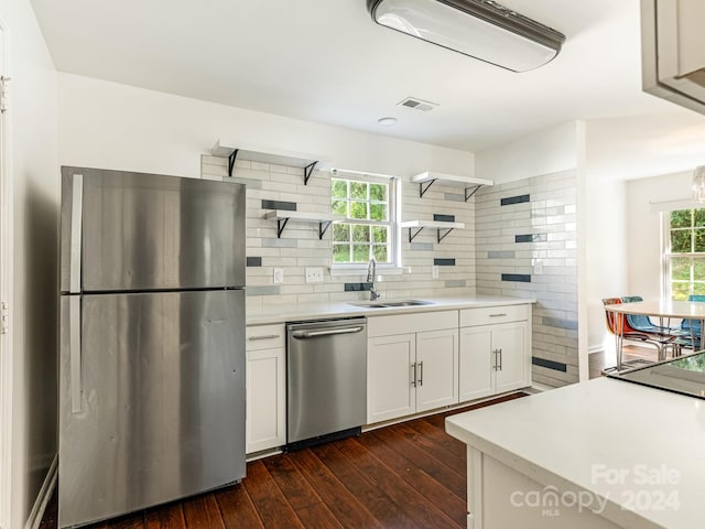 kitchen with dark hardwood / wood-style floors, sink, white cabinetry, appliances with stainless steel finishes, and backsplash