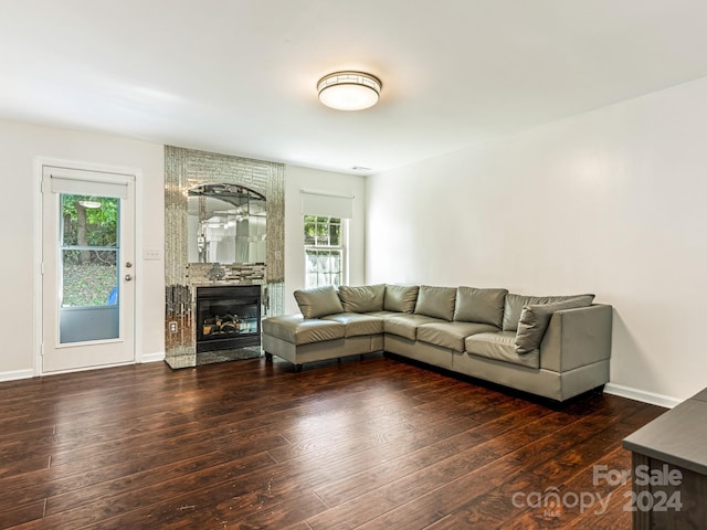 unfurnished living room with a large fireplace, dark hardwood / wood-style flooring, and a wealth of natural light