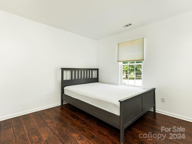 unfurnished bedroom with dark hardwood / wood-style flooring