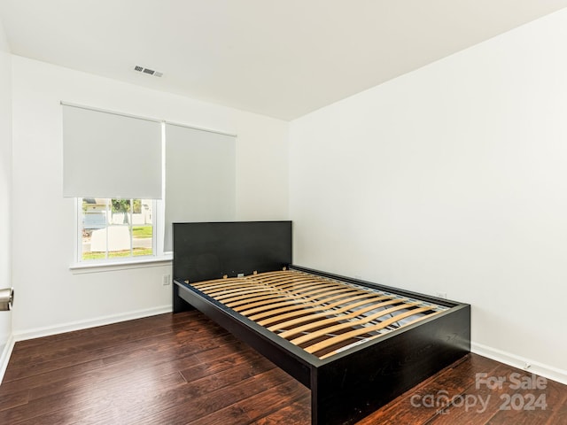 bedroom with dark wood-type flooring