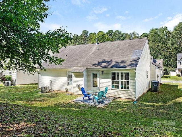 rear view of house featuring central air condition unit, a patio, and a lawn