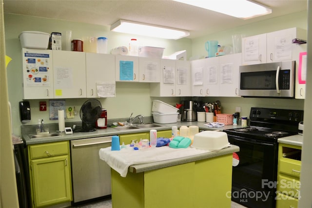 kitchen featuring green cabinetry, stainless steel appliances, sink, and a center island