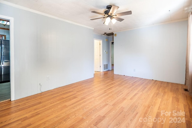 empty room featuring crown molding, ceiling fan, and light wood-type flooring