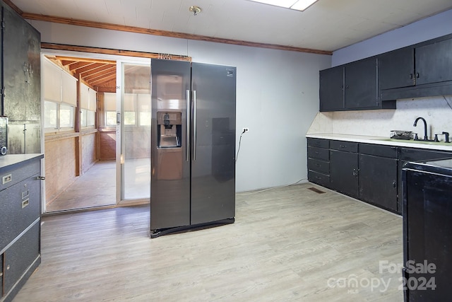 kitchen with stainless steel fridge, crown molding, sink, and light hardwood / wood-style flooring