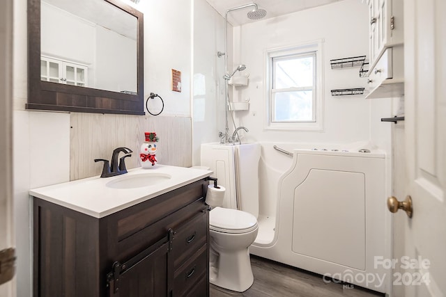 bathroom featuring vanity, hardwood / wood-style flooring, toilet, and washing machine and clothes dryer