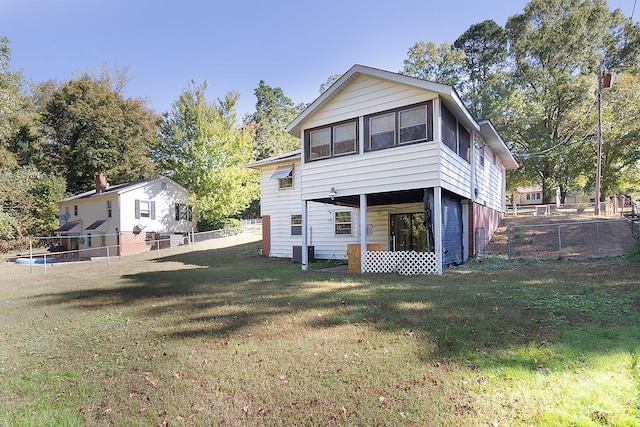 rear view of property featuring a lawn