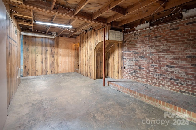 basement featuring wood walls