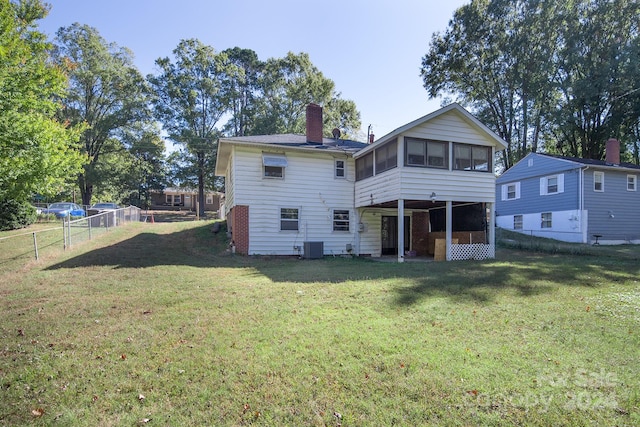 back of property featuring a yard, central AC, and a sunroom