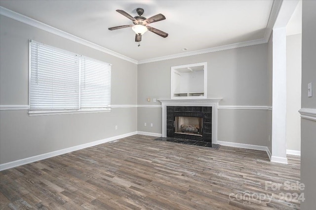 unfurnished living room with a fireplace, wood-type flooring, ornamental molding, and ceiling fan